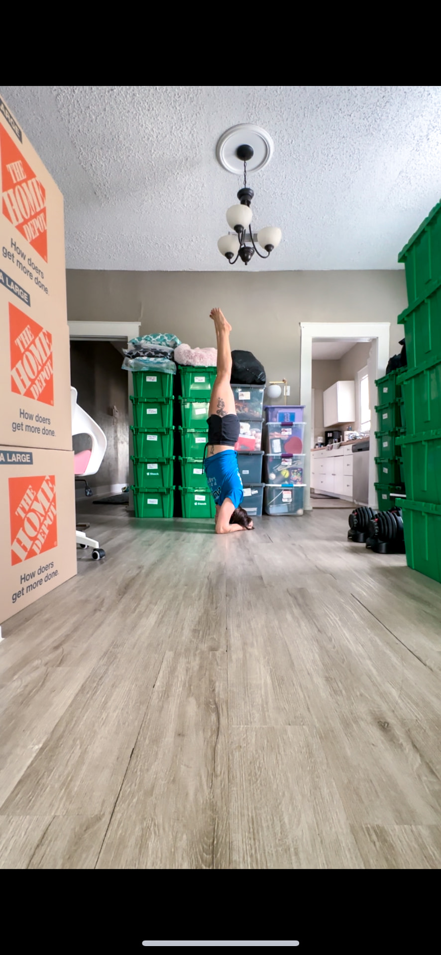 Doing a headstand mid-move, surrounded by packed boxes